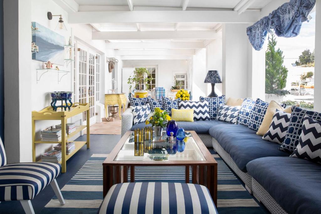 a living room with blue and white couches and a table at Our Hermanus House in Hermanus