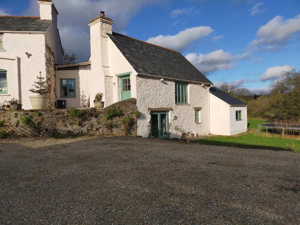 Casa de piedra blanca con entrada de grava en Coed Canol Farm, en Abergavenny
