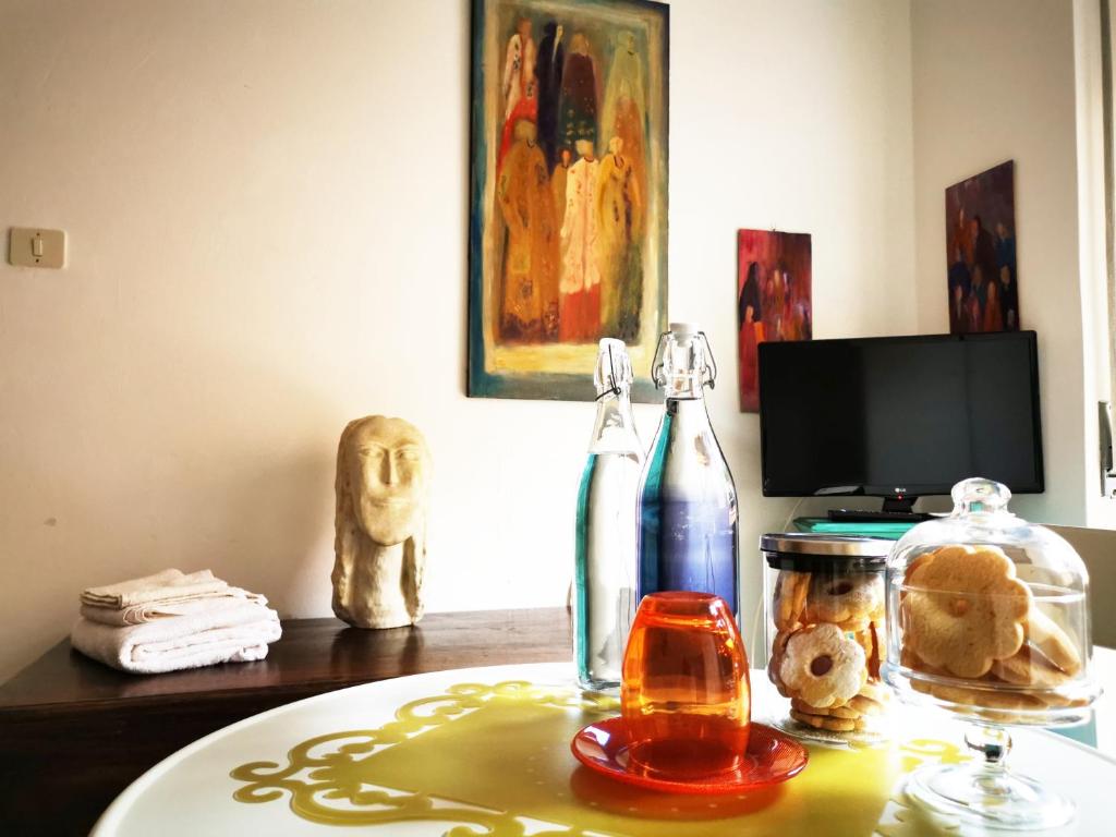 uma mesa com uma garrafa de vinho e um copo em Amariglio Apartment em Sassari
