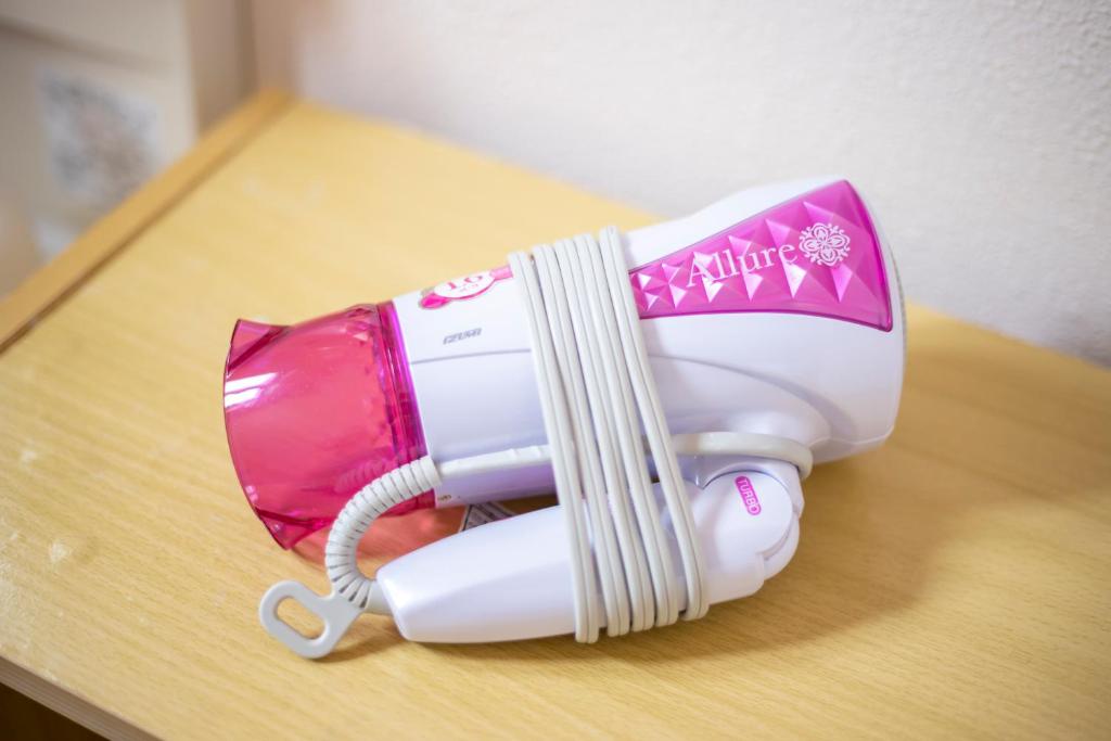 a white and pink blow dryer sitting on a table at kamekamehouse in Tokashiki