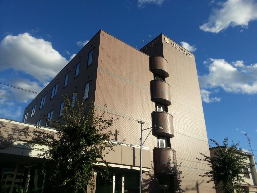 un gran edificio con un edificio con un poste delante en Hotel Sunfuraton, en Furano