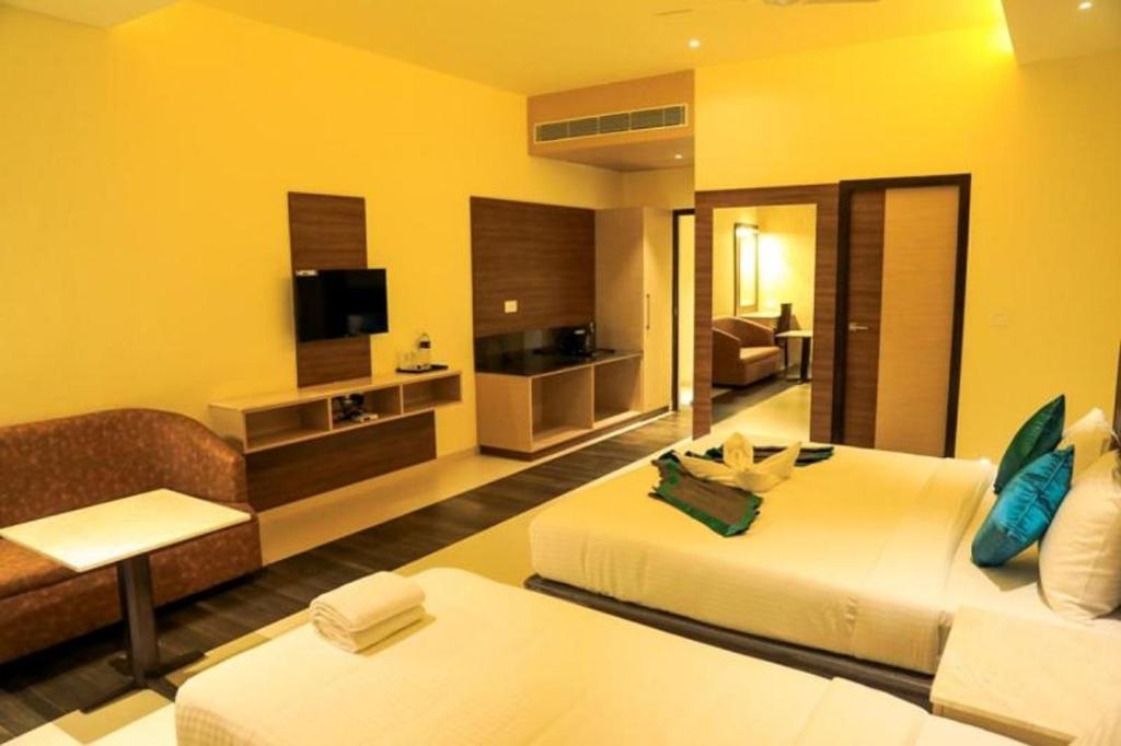 a hotel room with two beds and a television at Laya Regency in Mayiladuthurai