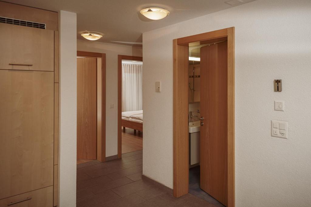 a hallway with a door and a room with a bed at Haus Mischabel in Zermatt