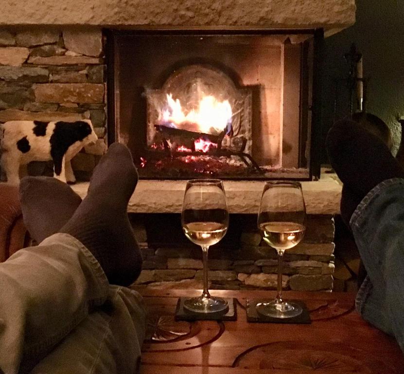 a person laying on a couch with two glasses of wine at La Residence-Your home away from home in Crans-Montana in Crans-Montana