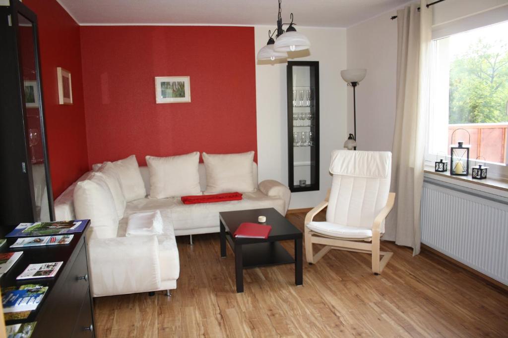 オルスベルクにあるFerienwohnung Panorama IIの白いソファと赤い壁のあるリビングルーム