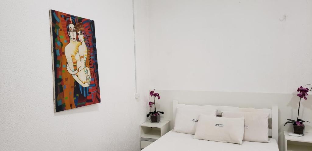 um quarto com uma cama com um quadro na parede em Hospedagem São Francisco em São Luís
