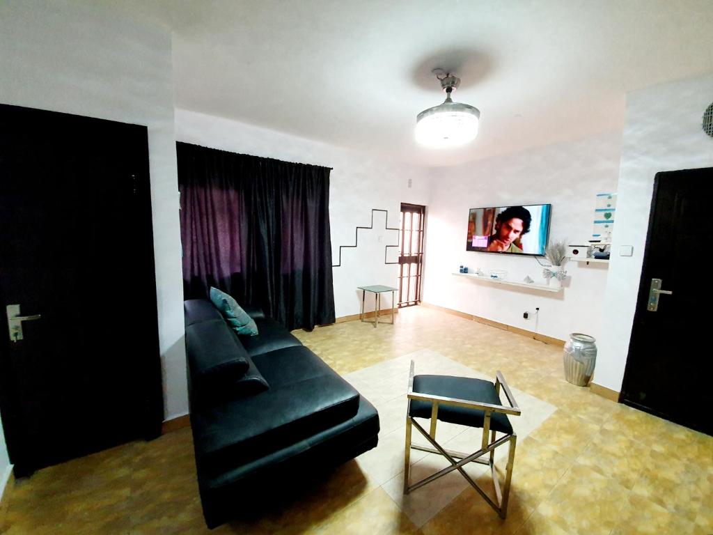 イケジャにあるEpic Prime Apartmentsのリビングルーム(黒いソファ、テーブル付)