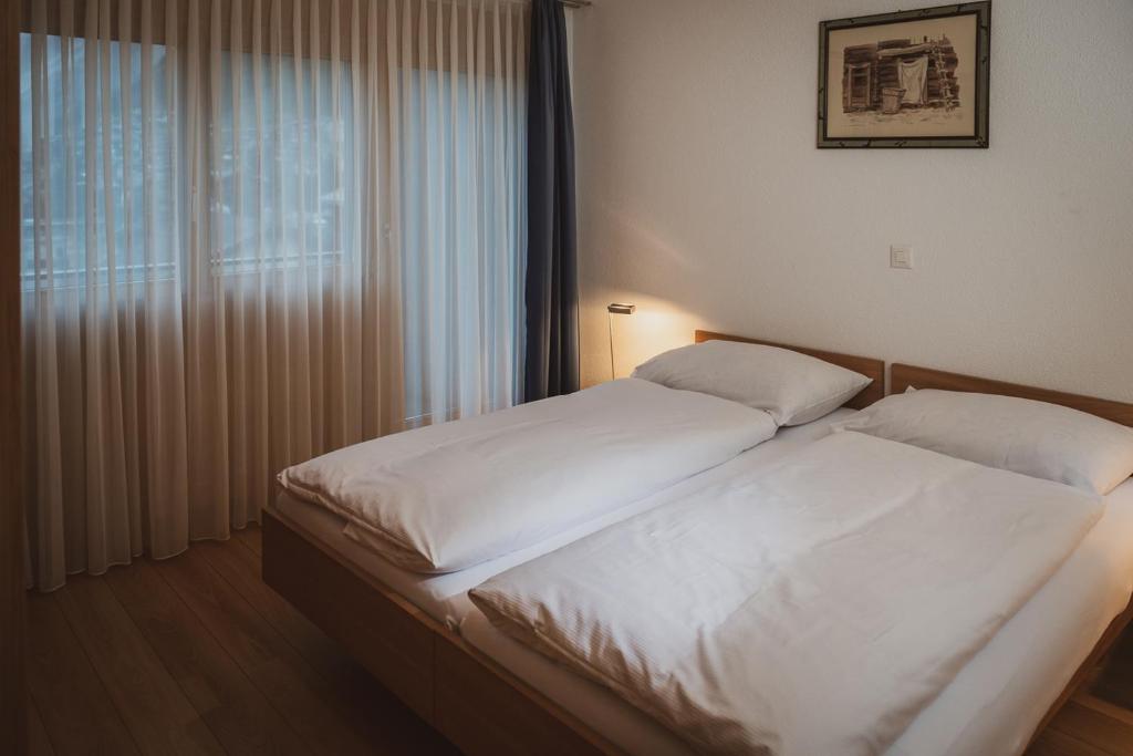 a bedroom with two beds and a window at Haus Mischabel in Zermatt
