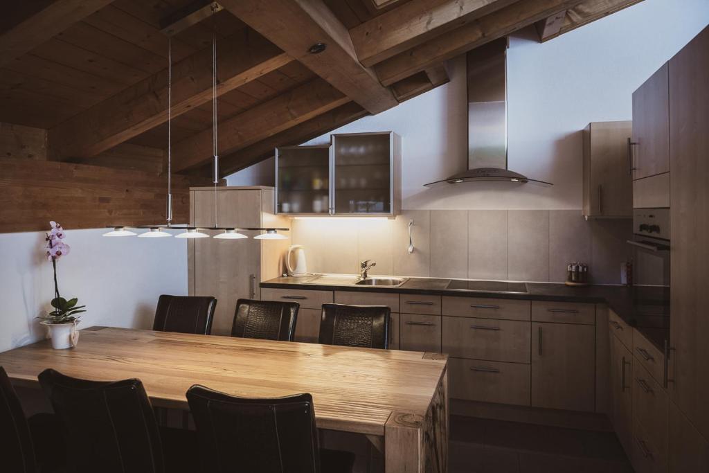 a kitchen with a wooden table and some chairs at Haus Mischabel in Zermatt