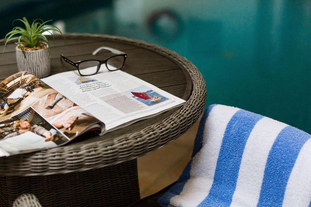 a wicker table with a magazine and glasses on it at Beachlands Hotel in Weston-super-Mare