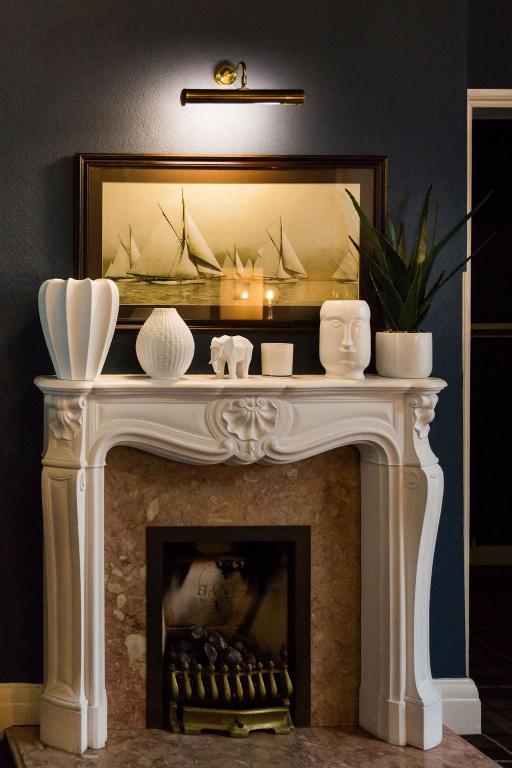 a fireplace with a mirror above it in a living room at Beachlands Hotel in Weston-super-Mare