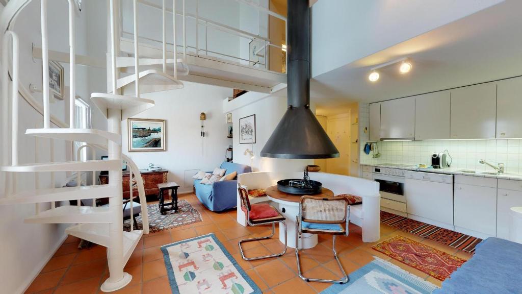 uma cozinha e uma sala de estar com uma escada em espiral em Polaschin D7 em Sils Maria