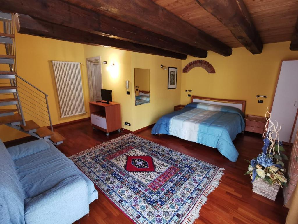 a bedroom with a bed and a couch at All'Imperatore in Cherasco