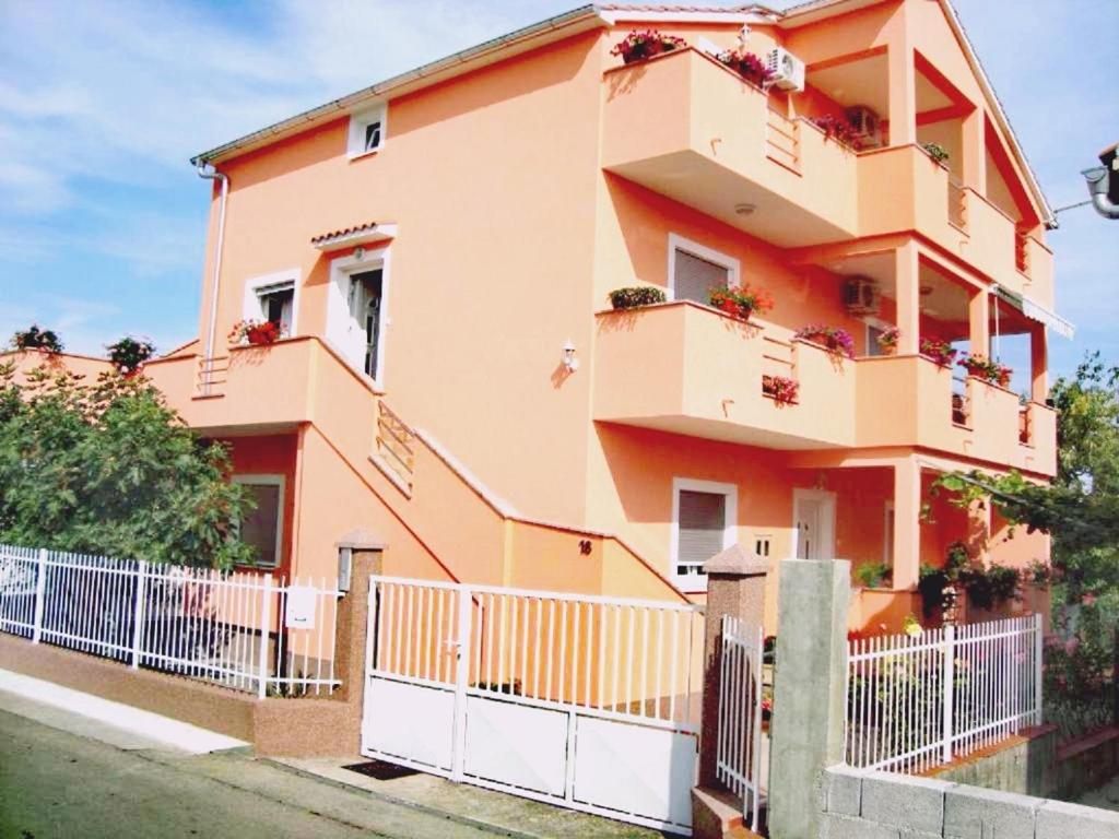 een gebouw met balkons en een hek ervoor bij Tena Apartment in Zadar