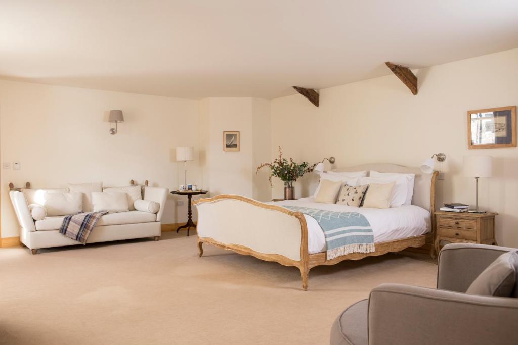 1 dormitorio grande con 1 cama y 1 sofá en Cragend Grange en Rothbury