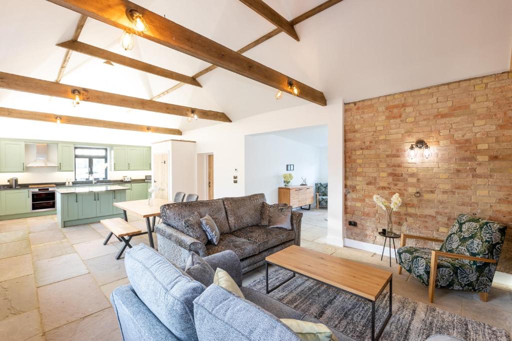 a living room with a couch and a table at The Yard @ Pringle Farm in Great Stukeley