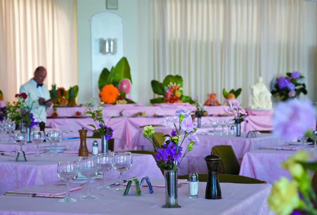 Pokój ze stołami z fioletowymi obrusami w obiekcie Hotel Terme Alexander w mieście Ischia