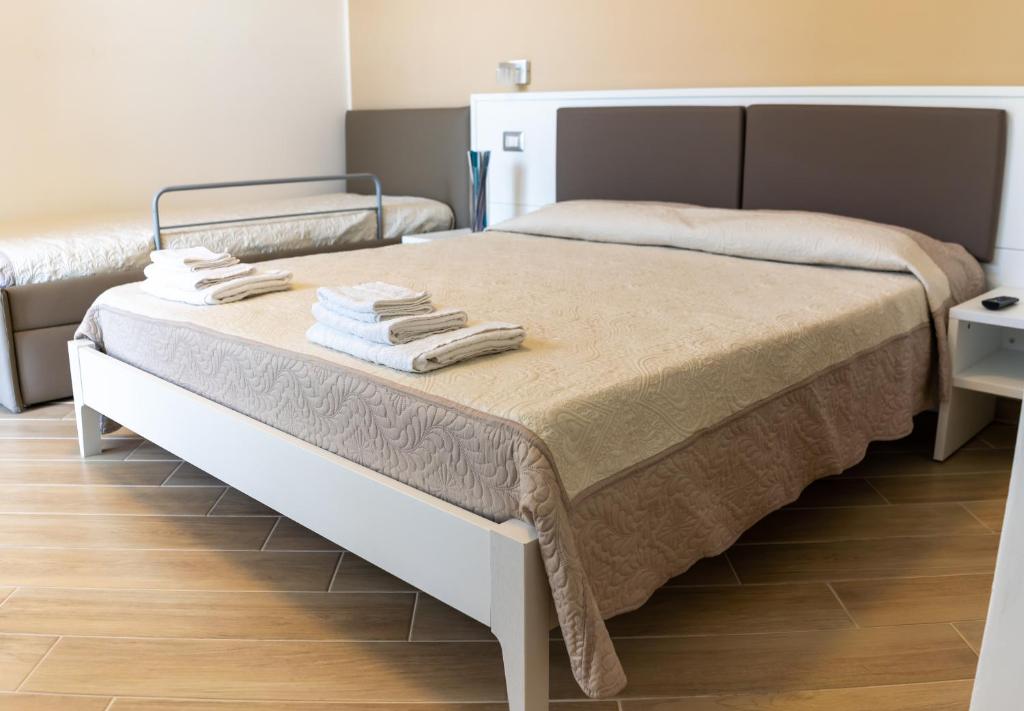 Blu Palinuro في بالينورو: غرفة نوم عليها سرير وفوط