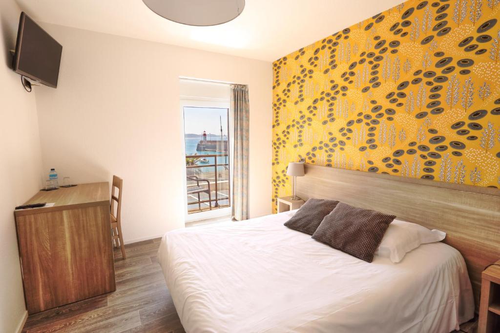 1 dormitorio con cama y pared amarilla en La Table De Jeanne, en Erquy