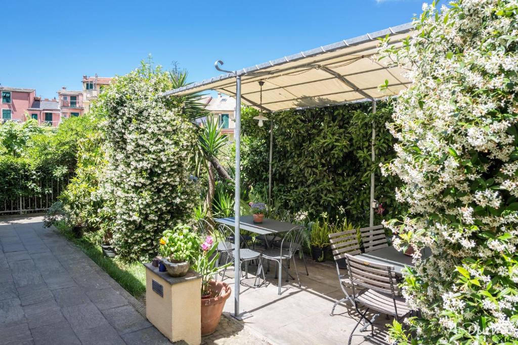 eine Terrasse mit einem Tisch und Stühlen unter einer Pergola in der Unterkunft A Durmì in Levanto