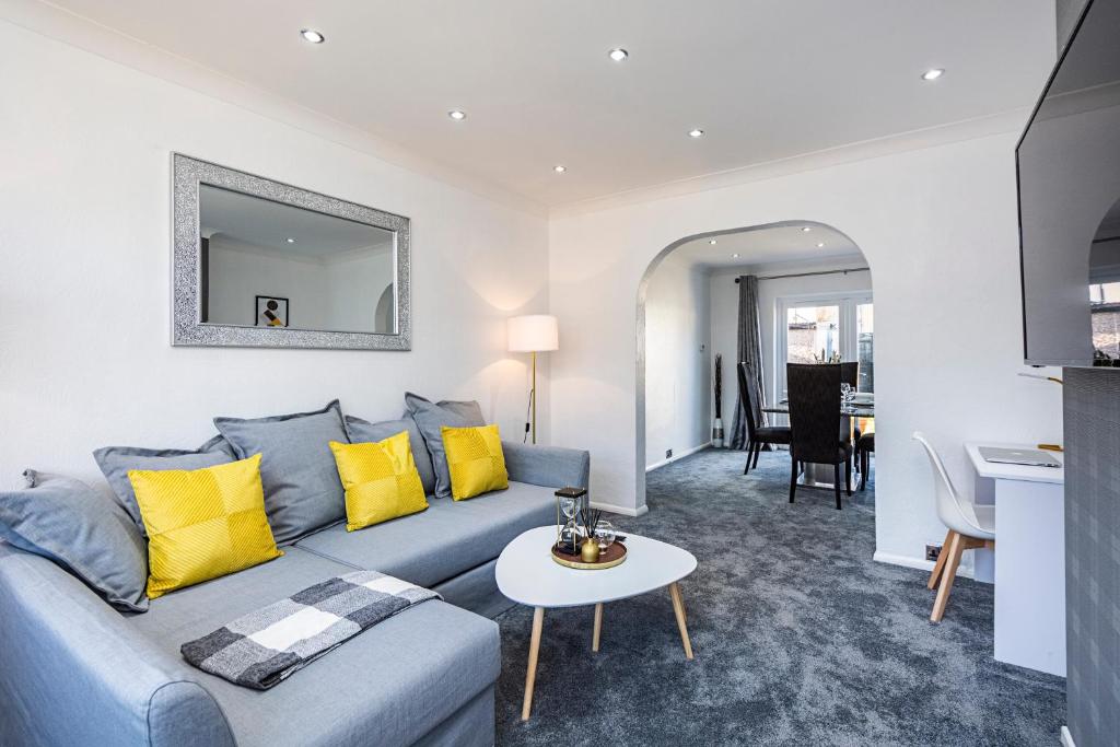 a living room with a blue couch and yellow pillows at Cozy 3 Bedroom House in Aveley, Thurrock in Aveley