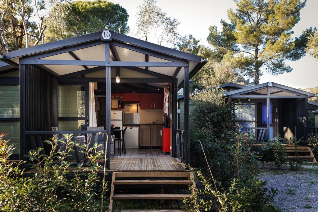 a black shed with a wooden deck and a kitchen at Oasi Camping in Diano Marina