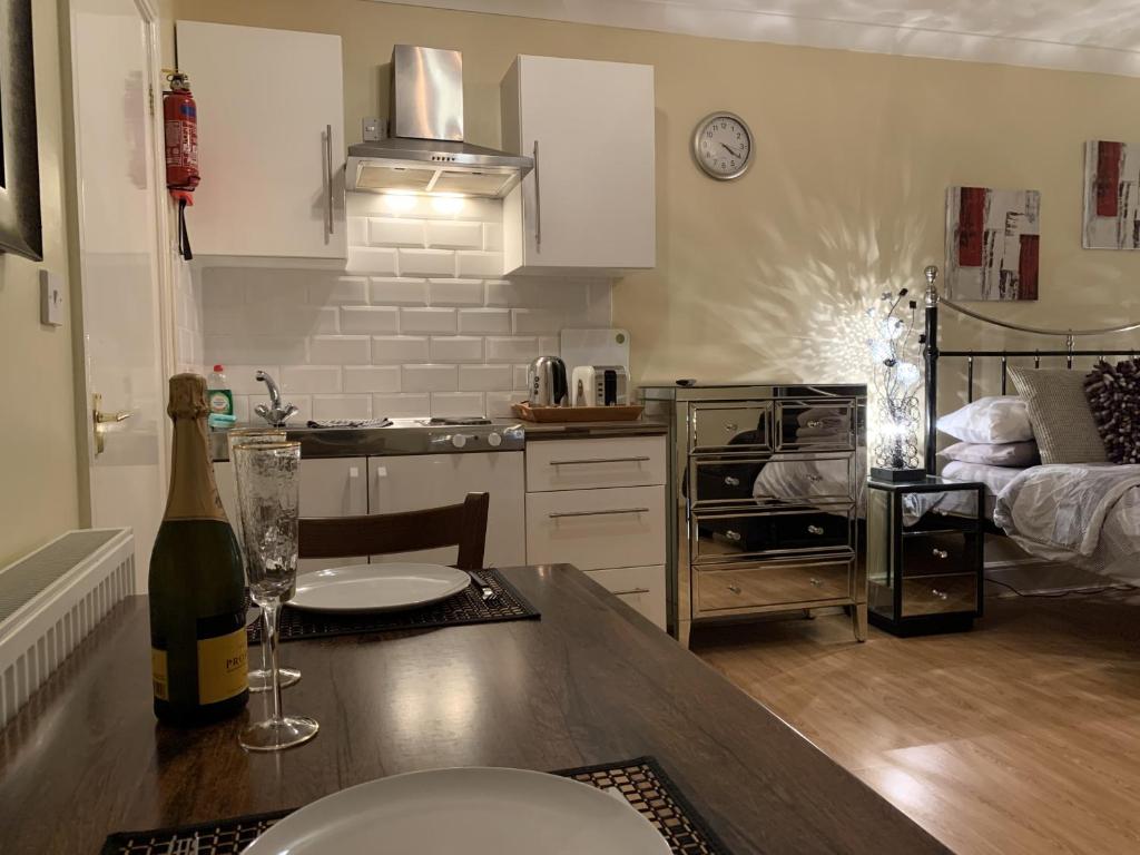 a kitchen with a table with a bottle of wine at Southernwood - Studio 2 in Didcot