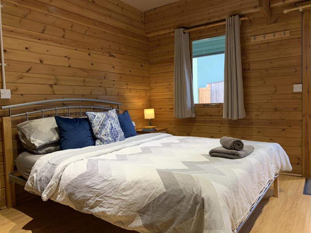 um quarto com uma cama num chalé de madeira em Southernwood - Garden Lodge 1 em Didcot