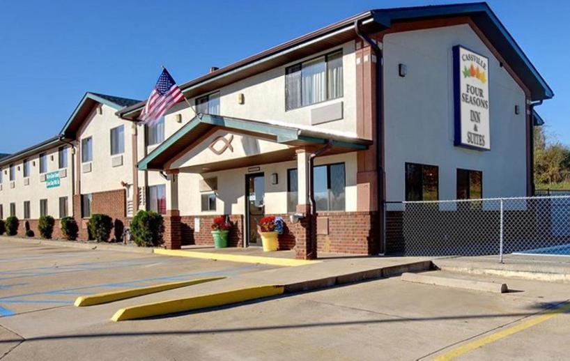 ein Gebäude mit amerikanischer Flagge auf einem Parkplatz in der Unterkunft Cassville Four Seasons Inn & Suites in Cassville