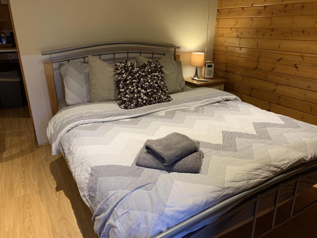 a large bed with pillows on it in a bedroom at Southernwood - Garden Lodge 5 in Didcot