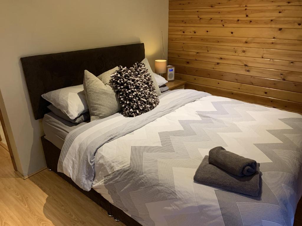 a bedroom with a large bed with a wooden headboard at Southernwood - Garden Lodge 7 in Didcot