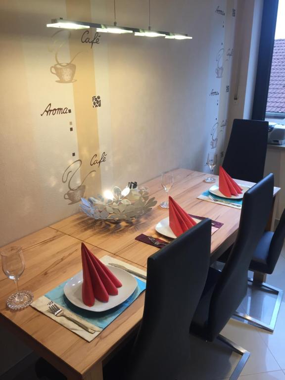 drewniany stół z czerwonymi serwetkami na górze w obiekcie Exclusive Living Apartment 2 Zimmer bis zu 4 Personen w Norymberdze