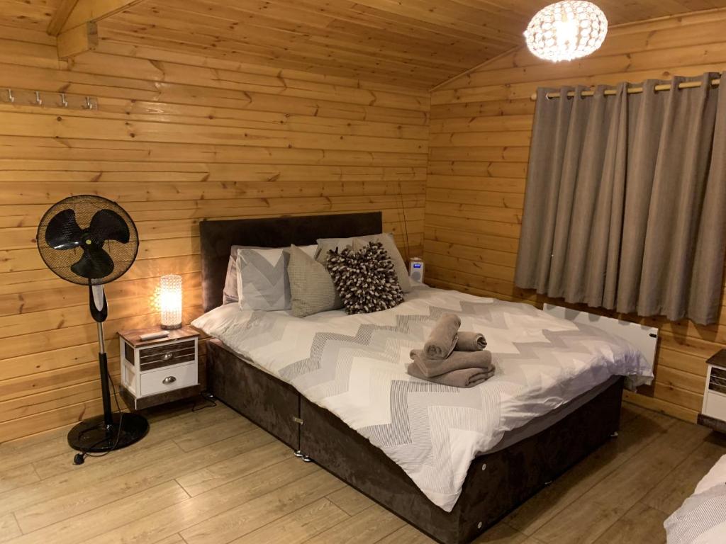 a bedroom with a large bed in a log cabin at Southernwood - Garden Lodge 9 in Didcot