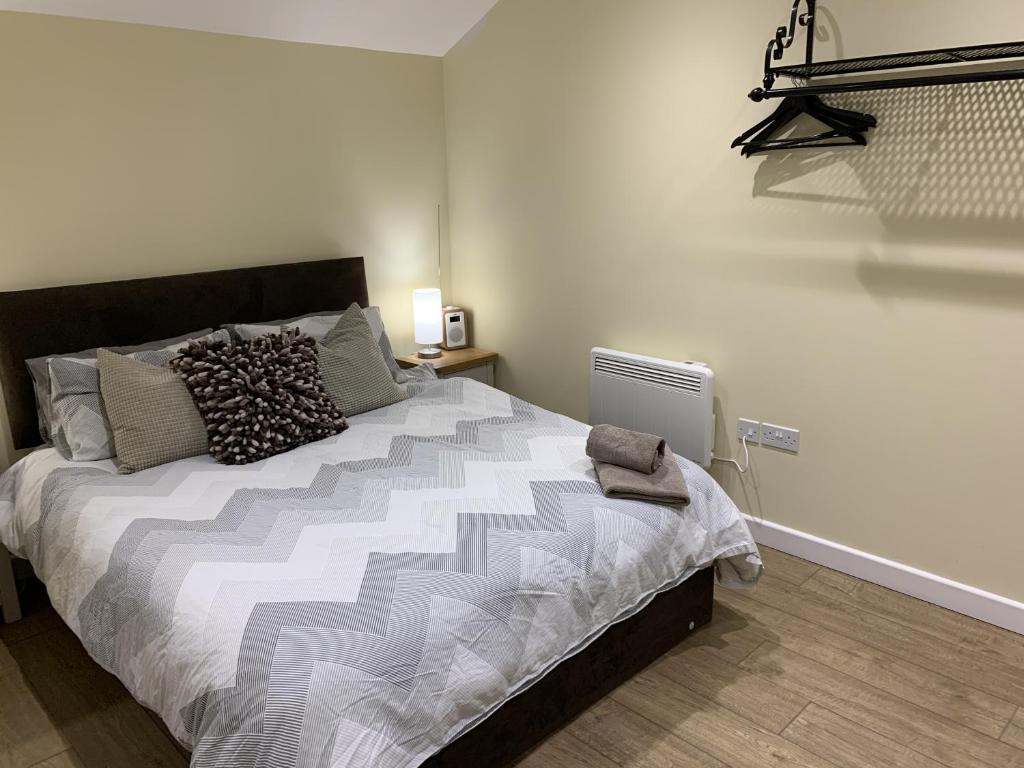 a bedroom with a large bed with pillows on it at Southernwood - Garden Lodge 12 in Didcot