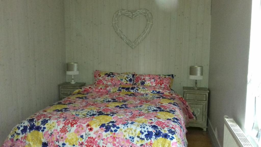 a bedroom with a bed with a heart on the wall at Duplex La Maisonnette 2 Chambres - parking gratuit in Troyes