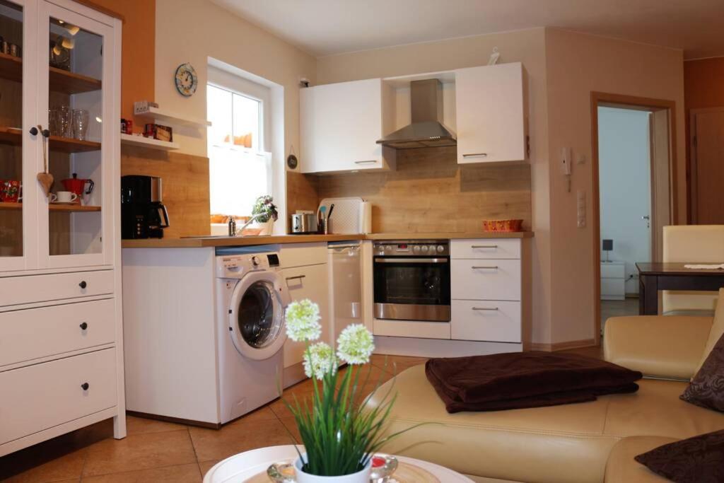 a kitchen with white cabinets and a washer at Kuschelige Ferienwohnung nahe Kronach in Kronach