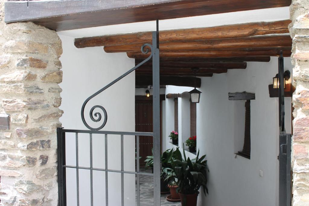 una entrada a una casa con una puerta de hierro forjado en Apartamentos Rurales Rosendo: La Orquídea en Capileira