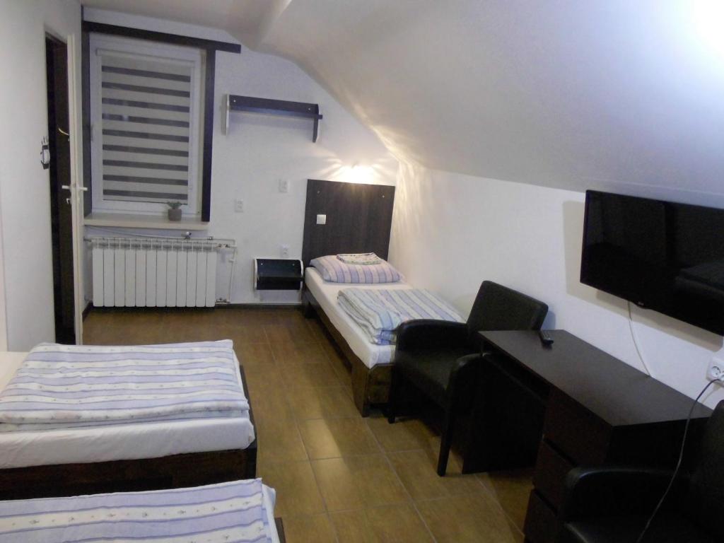 Mały pokój z 2 łóżkami i biurkiem w obiekcie Gościniec Nad Jarem w Gołdapi