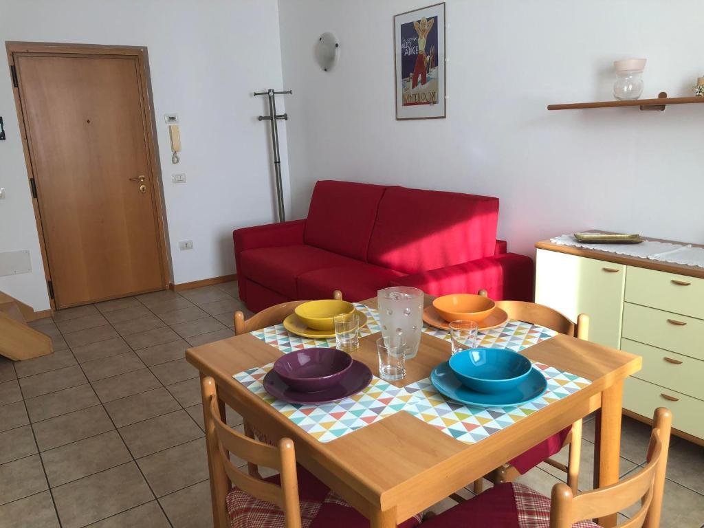 - une table avec des assiettes et des bols dans la cuisine dans l'établissement Appartamento a Spinazzeda cuore di Cles, à Cles