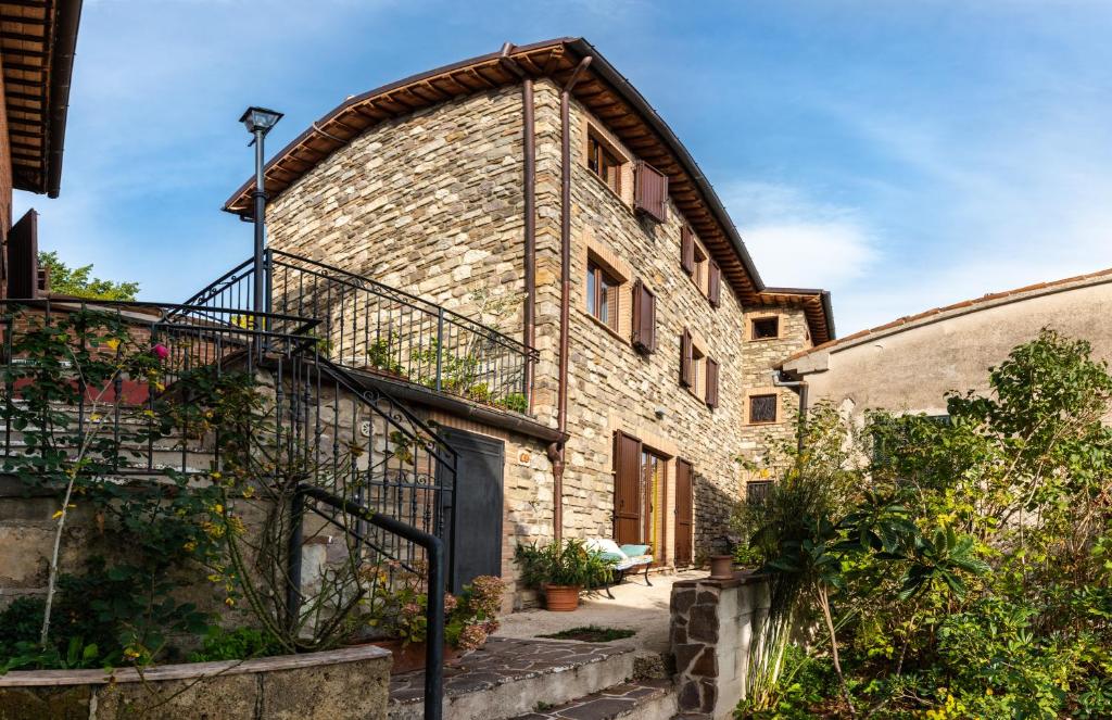 Habitación con balcón y vistas al exterior de un edificio de ladrillo. en Locanda della Rocca en Sarnano