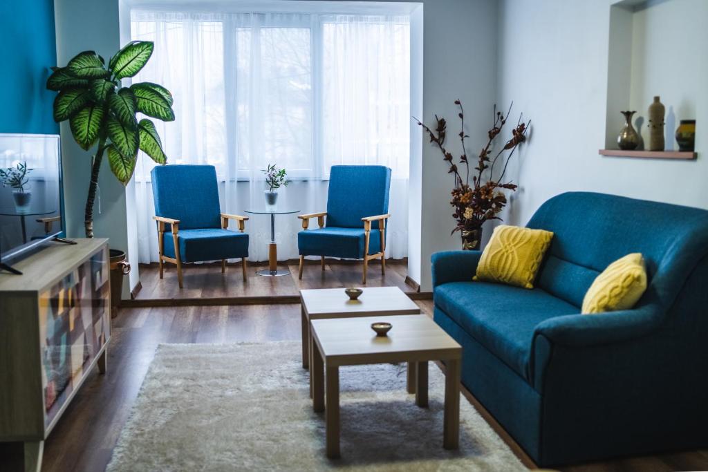 a living room with a blue couch and a table at Hideout Apartment in Predeal