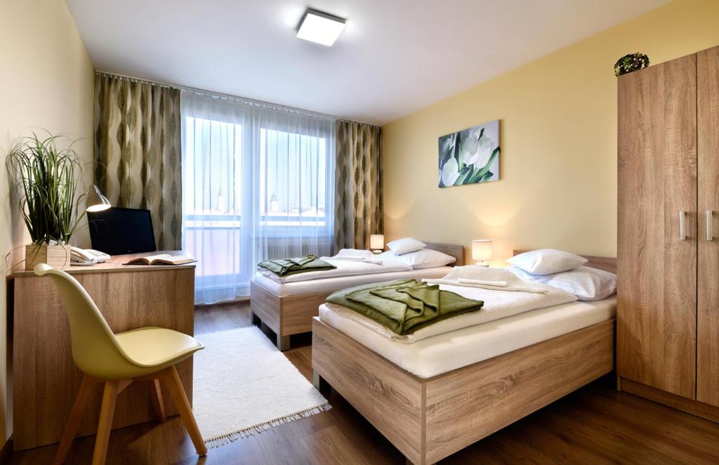 a hotel room with two beds and a chair at Hotel Pelikán in Lučenec