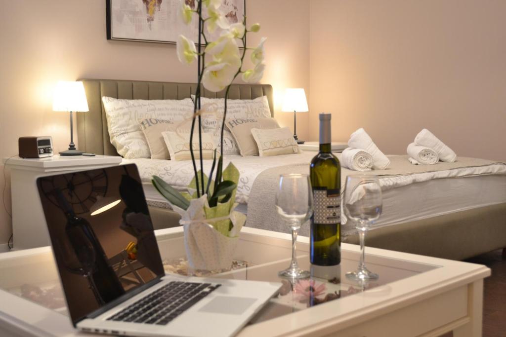 a bedroom with a bed with a laptop and wine glasses at City Centre Dream place in Zagreb
