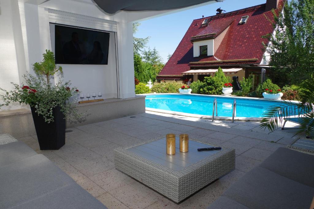 un patio con piscina y una mesa junto a una casa en Gästehaus Gaens - Ferienzimmer en Schirgiswalde