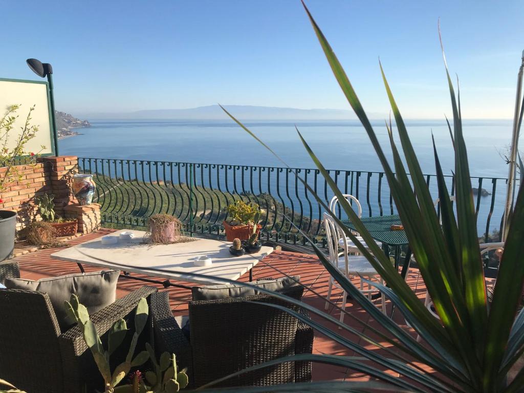 B&B La Terrazza Sul Mare Taormina في تاورمينا: فناء مع طاولة وإطلالة على المحيط