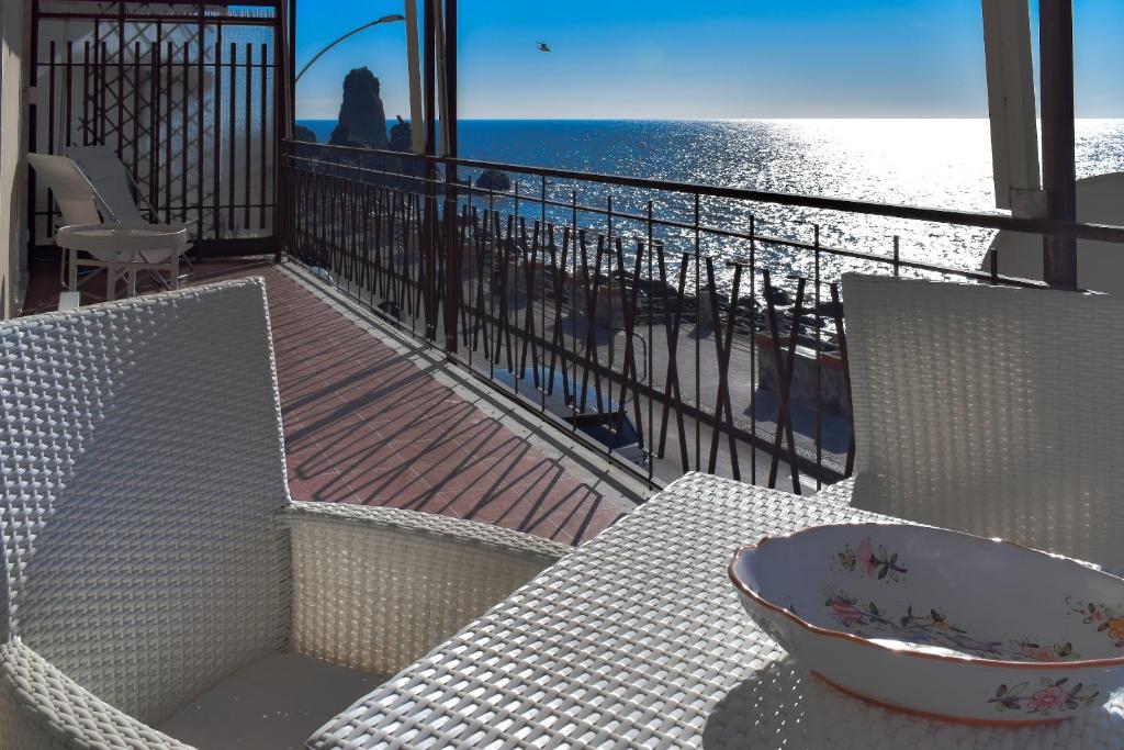 - un balcon avec une table et des chaises et la plage dans l'établissement Acitrezza View, à Aci Castello