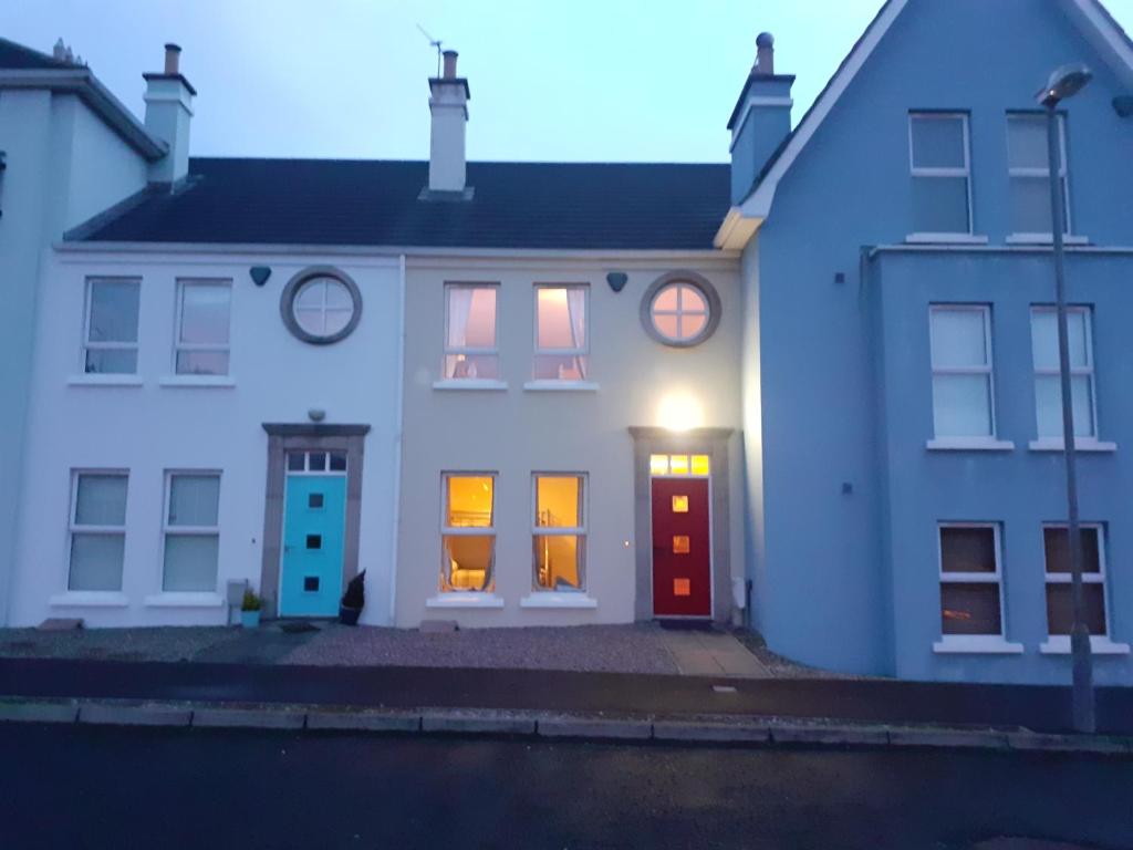 a white house with a christmas light in the window at Beachside Holiday Home in Portrush