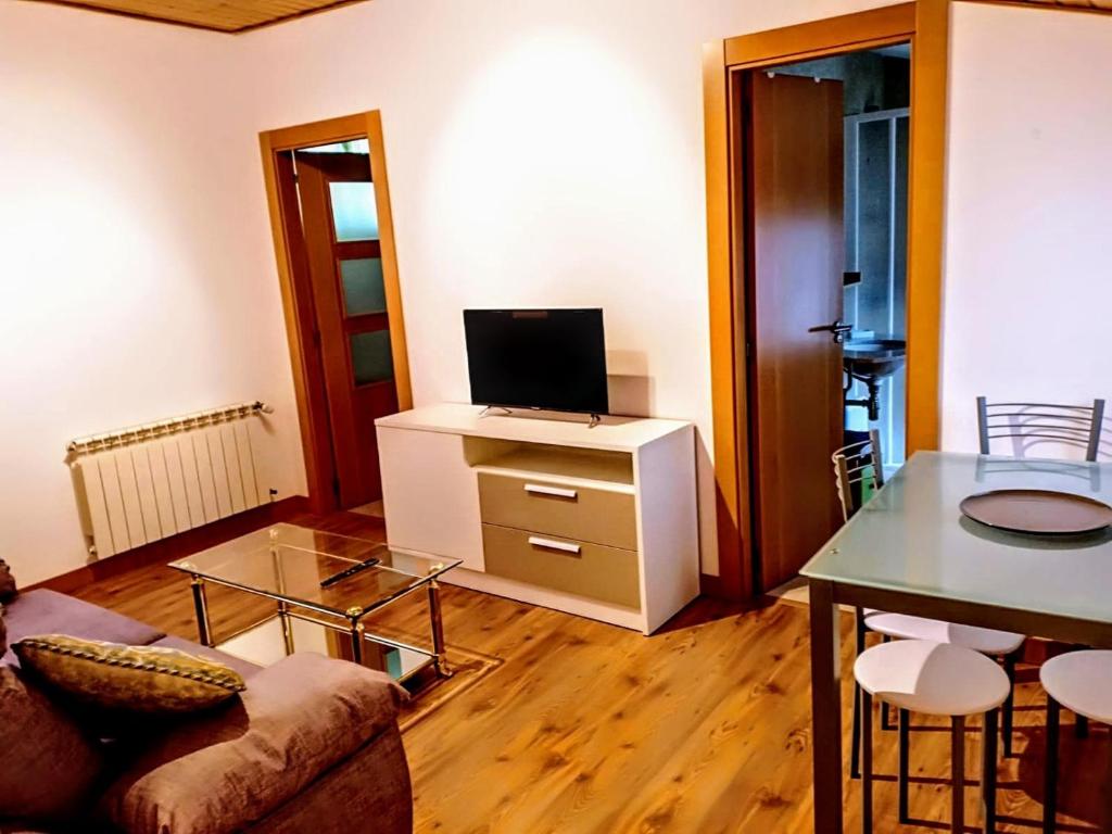 a living room with a couch and a tv on a cabinet at La ventana de la catedral in Burgos