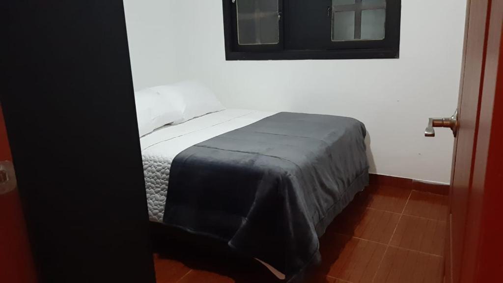 - une chambre avec un lit doté d'une couverture noire dans l'établissement apartamento tejares de Salento, à Salento