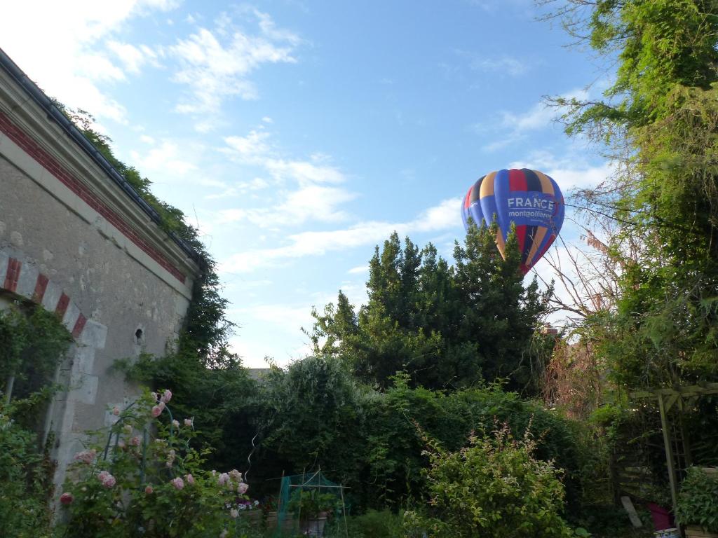 un globo de aire caliente está volando en el cielo en La Lézardière en Épeigné-les-Bois